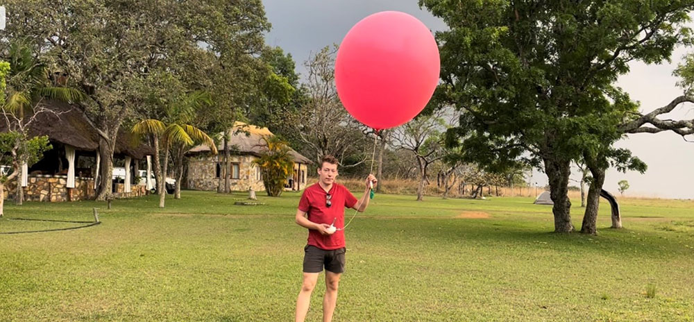 First year DPhil student, formerly SoGE undergraduate, winner of H.O.Beckit prize in 2022, Charlie Knight with a radiosonde at Nchila Camp, NW Zambia