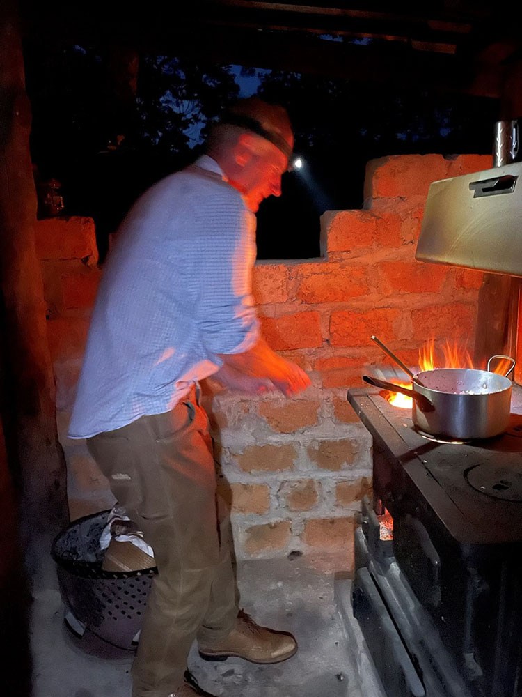 Richard Washington cooking dinner on a wood stove, Nchila Camp, NW Zambia