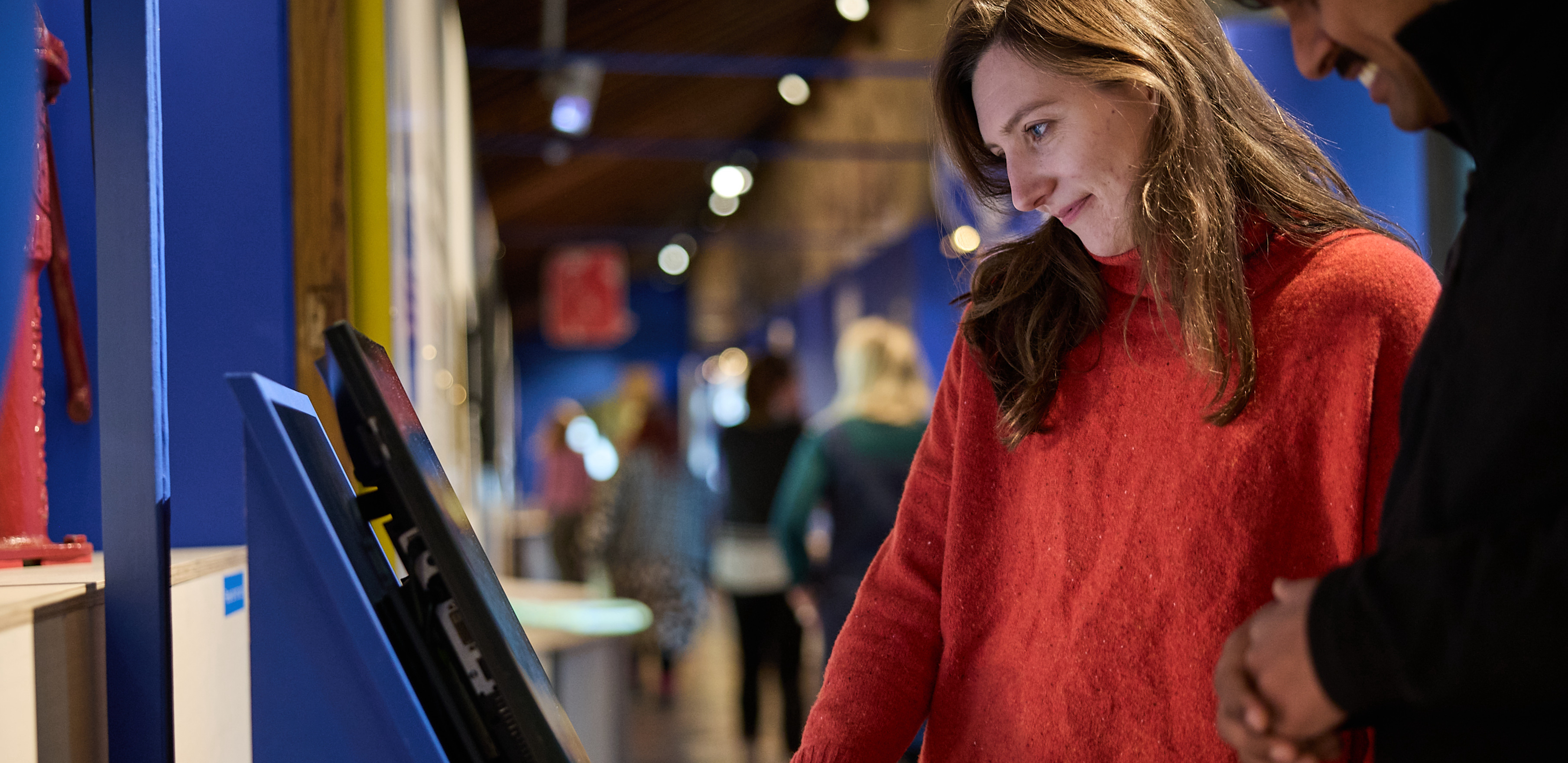 Man and woman looking at screen in exhibition