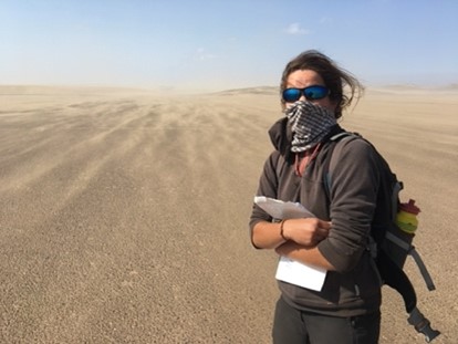 Postdoctoral researcher Pauline Delorme evaluating field monitoring sites for dune initiation experiments in high winds on the Skeleton Coast of Namibia.