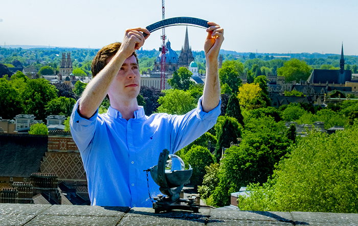 Thomas Caton Harrison, from the University's School of Geography and the Environment, uses a Campbell-Stokes recorder to measure Oxford's sunshine
