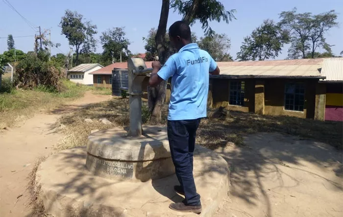 FundiFix mechanic inspecting a non-functioning handpump.