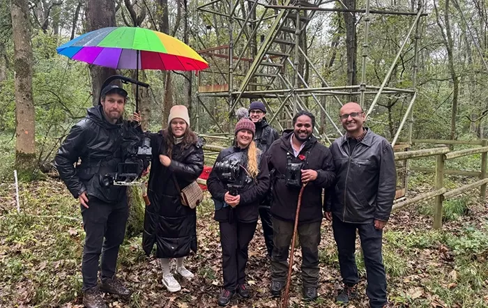 Professor Yadvinder Malhi (right) with the BBC Countryfile team, including presenters Hamza Yassin and Ellie Harrison, in front of the Flux Tower in Wytham Woods.