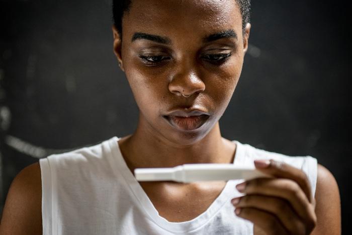 Woman looks at pregnancy test