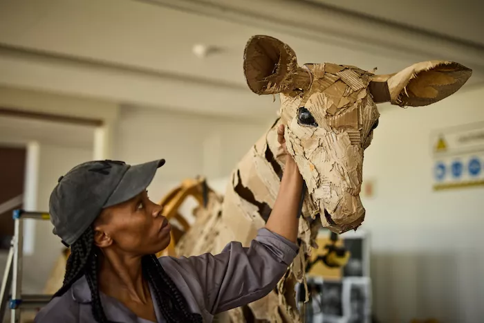 The Herds puppeteer with a life-size animal puppet
