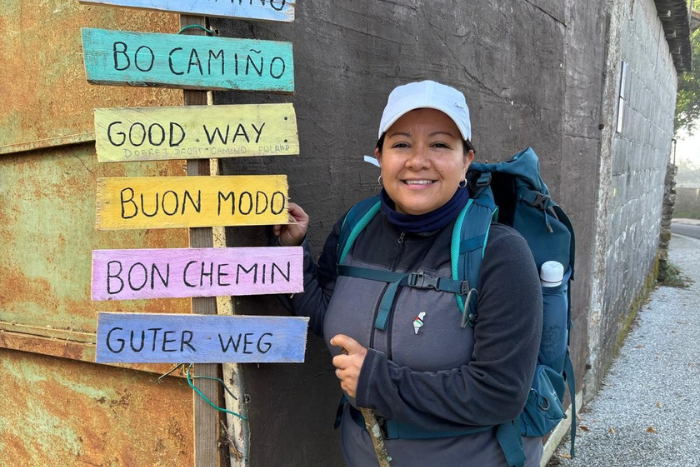 Angela with signs on the Camino de Santiago