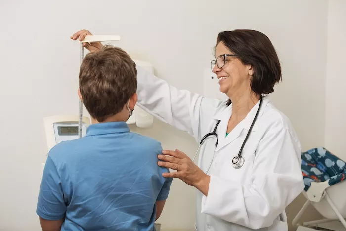 Stock photo of a doctor measuring a child's height